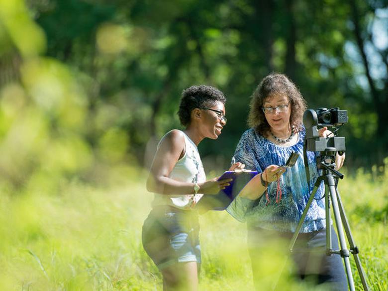 Professor working with a female student outdoors